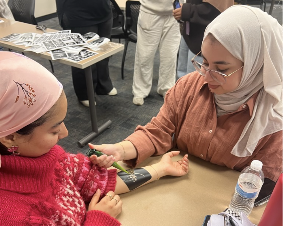 Amani Taleb (left) and Fatemah Almahmeed (right) practice the art of henna on one another at the Ladies Henna Night, Oct. 25, 2024.
